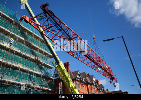 Studentenunterkunft in Liverpool, Merseyside, Großbritannien 21. März 2015. 40m hoher roter Turmdrehkran, der auf der Baustelle eines großen Komplexes von Nordic Construction verwendet wurde, der entfernt wird. Der Standort in der Hope Street ist ein Studentenzentrum mit 339 Zimmern, einem Fitnessstudio, einem Kino, Bars und Restaurants. Der Kran wird mit einem noch größeren 750 Tonnen Luffer Crane mit hydraulischen Wippauslegern demontiert (wird in engen städtischen Arbeitsräumen verwendet, wenn der Abstand zum Drehen des Jib nicht ausreicht), Einer der größten Krane dieser Art in Europa und einer von nur drei in Großbritannien. Stockfoto