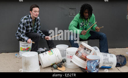 Zwei Straßenmusiker, die Busker blasen, schlagen den Rhythmus auf Trommeln, die auf der Straße, Philadelphia, USA, improvisiert wurden Stockfoto
