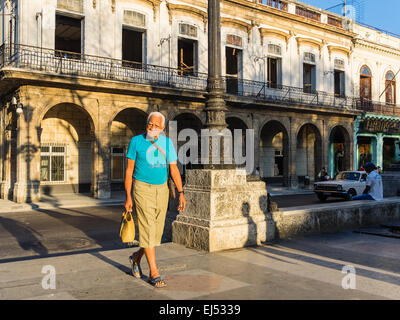 Eine männliche Senioren mit grauen Haaren geht in das Licht des frühen Morgens in Havanna. Stockfoto