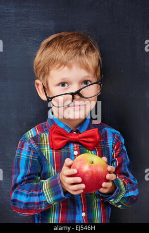 Mixed-up Ingwer Grundschule Alter Junge mit roter Apfel Stockfoto