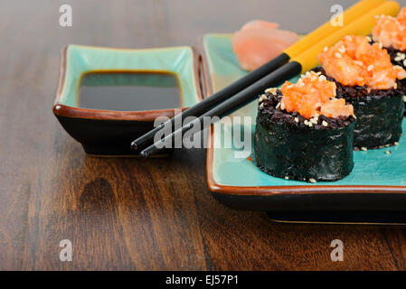 Gebackenes Sushi-Rollen auf blauen Teller serviert Stockfoto