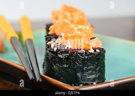 Gebackenes Sushi-Rollen auf Türkis Teller serviert Stockfoto