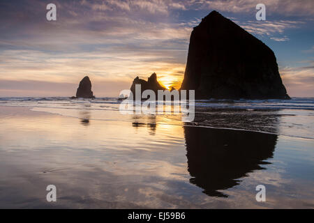 Sonnenuntergang über Haystack Rock und andere Meer-Stacks in Cannon Beach, Oregon, USA. Stockfoto