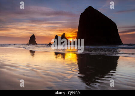 Sonnenuntergang über Haystack Rock und andere Meer-Stacks in Cannon Beach, Oregon, USA. Stockfoto