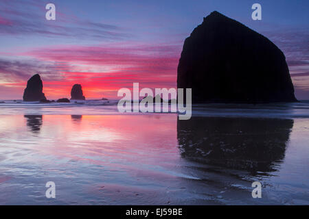 Sonnenuntergang über Haystack Rock und andere Meer-Stacks in Cannon Beach, Oregon, USA. Stockfoto