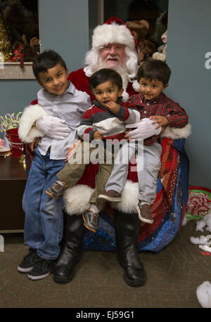 Kleine Jungs sitzen auf Santas Schoß am Weihnachtsessen für uns Soldaten am Wounded Warrior Center, Camp Pendleton, nördlich von San Diego, Kalifornien, USA Stockfoto