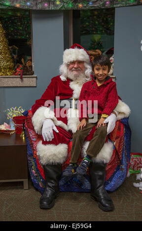 Kleiner Junge sitzt auf Santas Schoß am Weihnachtsessen für uns Soldaten am Wounded Warrior Center, Camp Pendleton, nördlich von San Diego, Kalifornien, USA Stockfoto