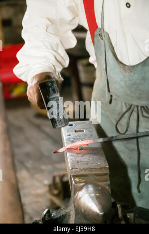 Schmiede arbeiten bei dem Amboss hämmern ein Stück glühendes Eisen in Form, genommen in der Schmiede in Galena, Illinois, USA Stockfoto