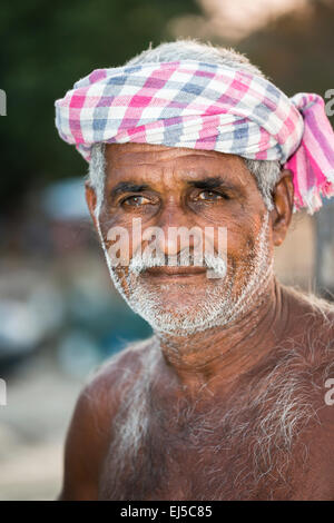 Keralan Lebensstil: freundliche lokale Fischer mit karierten turban Posen auf die chinesischen Fischernetze in Fort Cochin, Kerala, Südindien Stockfoto