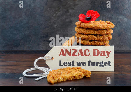 Australischen Anzac Kekse mit Anzac DAy, Lest We Forget Nachricht auf dunklem Holz und Schiefer Hintergrund. Stockfoto