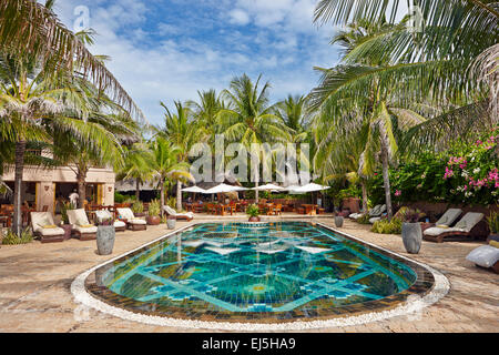 Swimmingpool, der von Palmen in Mia Resort Mui Ne umgeben. Mui Ne, Binh Thuan Provinz, Vietnam. Stockfoto