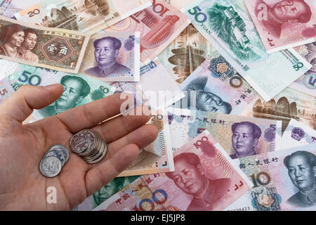Chinesische Geldzählen (RMB). Münzen mit RMB Banknoten im Hintergrund. Business-Konzept. Stockfoto