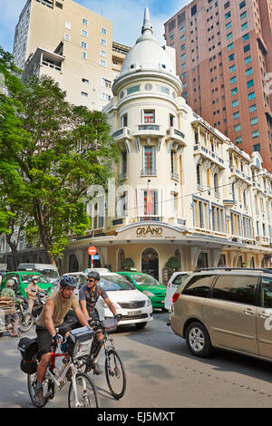 Zwei Männer Reiten Fahrräder bei Besetzt der Dong Khoi Street. District 1, Ho Chi Minh City, Vietnam. Stockfoto