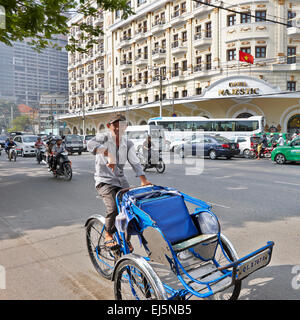 Cycle Rikscha bietet eine Fahrt auf der Straße in der Nähe des Majestic Hotel im Bezirk 1. Ho-Chi-Minh-Stadt, Vietnam. Stockfoto