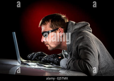 Hacker in einer Sonnenbrille mit Laptop. Stockfoto