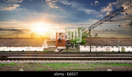 Schienen und industrielle Station bei Sonnenuntergang Stockfoto