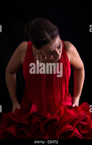 Flamenco-Tänzerin mit roten Kleid leidenschaftlich auf schwarzem Hintergrund Stockfoto