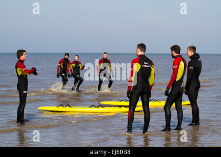 Freiwillige Rettungsschwimmer von RNLI üben bei Flut Rettungstraining und -Genesung auf dem Land auf Ainsdale, Merseyside, Strand. Surf Lifesaving ist ein Sport, der Leben retten kann und aus verschiedenen Rennen besteht – Schwimmen, Boardpaddeln und Skikaddeln. Simulierte Rettungen werden verwendet, um das Reagieren unter verschiedenen Bedingungen zu üben. Stockfoto