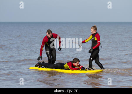 Freiwillige Rettungsschwimmer von RNLI üben bei Flut Rettungstraining und -Genesung auf dem Land auf Ainsdale, Merseyside, Strand. Surf Lifesaving ist ein Sport, der Leben retten kann und aus verschiedenen Rennen besteht – Schwimmen, Boardpaddeln und Skikaddeln. Simulierte Rettungen werden verwendet, um das Reagieren unter verschiedenen Bedingungen zu üben. Stockfoto