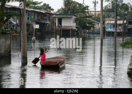 Manila, Philippinen. 22. März 2015. Ein junges Mädchen Paddel ihren Weg durch die überfluteten Straßen von Artex Verbindung. Rund 175 Familien leben in Artex Compound in Malabon, nördlich von Manila. Das Wohngebiet ist seit Mitte der 80er Jahre mit Taille Hochwasser überflutet. © J Gerard Seguia/Pacific Press/Alamy Live-Nachrichten Stockfoto