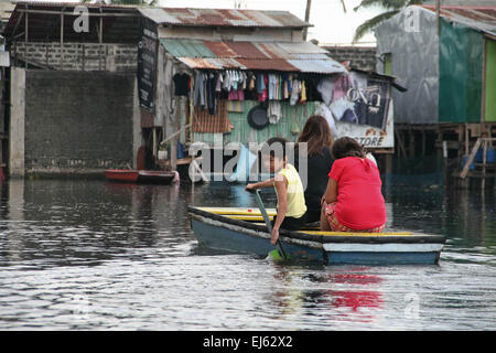 Manila, Philippinen. 22. März 2015. Ein kleiner Junge arbeitet als ein Boot-Paddler zur Fähre Pendler rund um die untergetauchten Community. Rund 175 Familien leben in Artex Compound in Malabon. Das Wohngebiet ist seit Mitte der 80er Jahre mit Taille Hochwasser überflutet. © J Gerard Seguia/Pacific Press/Alamy Live-Nachrichten Stockfoto