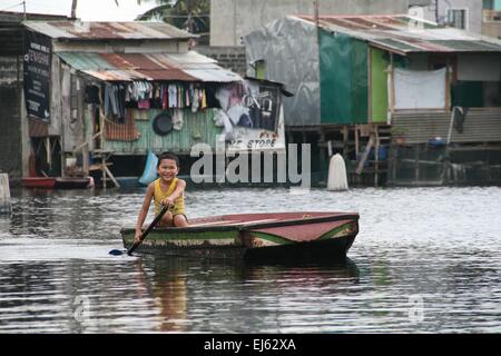 Manila, Philippinen. 22. März 2015. Ein kleiner Junge lächelt, als er seinen Weg durch die überfluteten Artex-Anlage Paddel. Rund 175 Familien leben in Artex Compound in Malabon, nördlich von Manila. Das Wohngebiet ist seit Mitte der 80er Jahre mit Taille Hochwasser überflutet. © J Gerard Seguia/Pacific Press/Alamy Live-Nachrichten Stockfoto