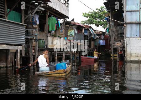 Manila, Philippinen. 22. März 2015. Ein kleiner Junge liefert ein Boot voller Wasserbehälter in Artex Verbindung. Rund 175 Familien leben in Artex Compound in Malabon. Das Wohngebiet ist seit Mitte der 80er Jahre mit Taille Hochwasser überflutet. © J Gerard Seguia/Pacific Press/Alamy Live-Nachrichten Stockfoto