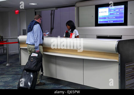 Passagiere am Flughafen am Check-in-Schalter im Gespräch mit Airline-agent Stockfoto