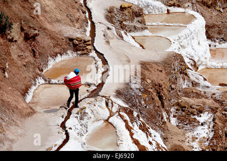 Person zu Fuß durch Salinen, Salineras (Salinen), Cusco, Peru Stockfoto