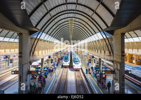 Passagiere und Züge am Bahnhof Santa Justa in Sevilla, Spanien. Stockfoto