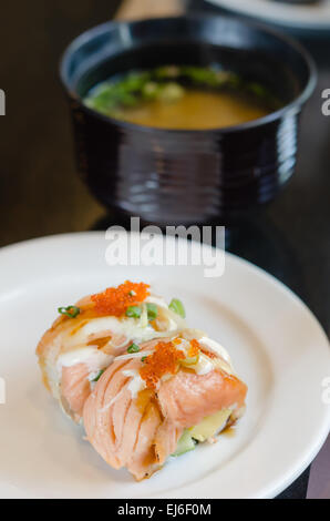 Gegrillter Lachs roll Sushi mit Shrimps Ei an der Spitze weiße Schale mit Miso-Suppe serviert Stockfoto