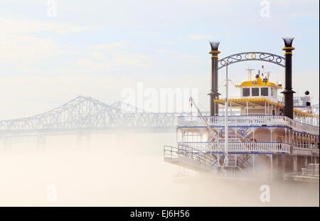 New Orleans, Louisiana. Creole Queen Kreuzfahrtschiff auf einer nebligen Mississippi mit Crescent City Connection-Brücke. Stockfoto