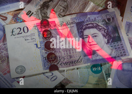 Eine negative Grafik, die auf einen Stapel britischer Banknoten projiziert wird. Stockfoto