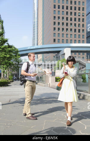 Junge japanische Mädchen Flucht aus ausländischen Touristen um Hilfe zu bitten Stockfoto