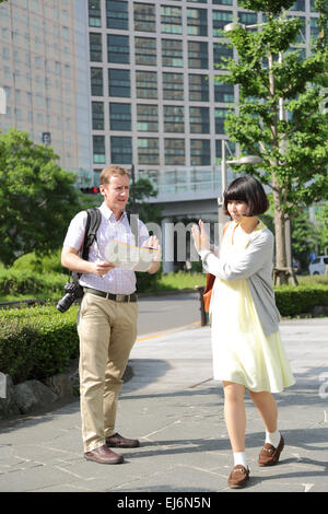 Junge japanische Mädchen Flucht aus ausländischen Touristen um Hilfe zu bitten Stockfoto