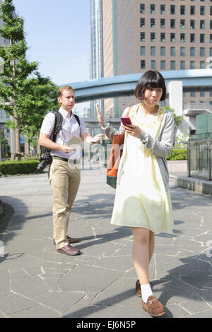 Junge japanische Mädchen Flucht aus ausländischen Touristen um Hilfe zu bitten Stockfoto