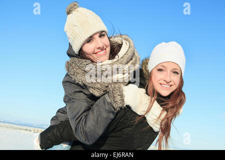 Zwei glückliche junge Mädchen, die Spaß in Winter park Stockfoto