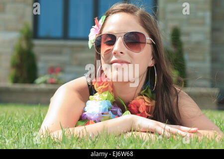 Eine junge Frau legte sich und machen Sie eine Pause auf dem grünen Rasen Stockfoto