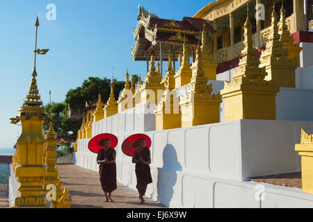 Mönche mit roten Regenschirm in Umin Thounzeh Pagode, Sagaing Hill, Mandalay, Myanmar Stockfoto