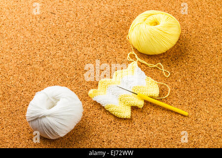 Rolle der weißen und gelben weich Strickgarn, stricken, Nadel auf Kork-Hintergrund Stockfoto