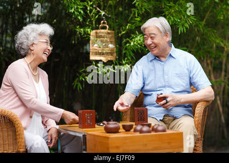 Das alte Ehepaar spielen Schach im Hof Stockfoto