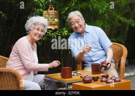 Das alte Ehepaar spielen Schach im Hof Stockfoto