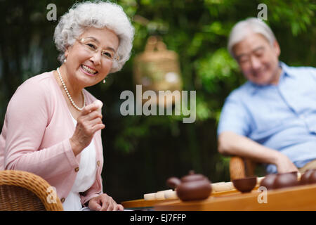 Das alte Ehepaar spielen Schach im Hof Stockfoto