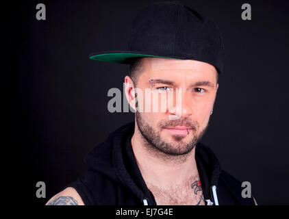 Eine Urban Mann tragen Baseball-Cap in schwarzem Hintergrund Studio. Stockfoto