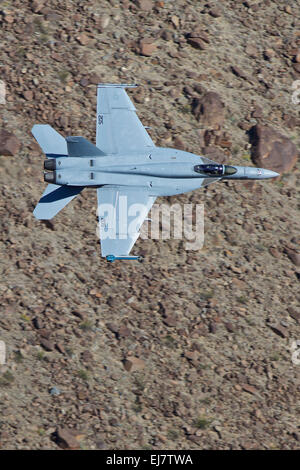 Nahaufnahme der US Navy F/A-18E Super Hornet Kampfjet Banking In einer Wüste Schlucht auf niedrigem Niveau. Stockfoto