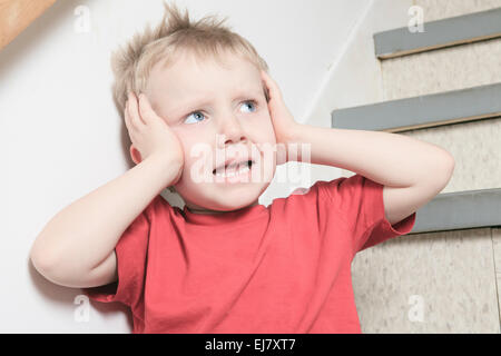 Vernachlässigte einsame Kind an die Wand gelehnt Stockfoto