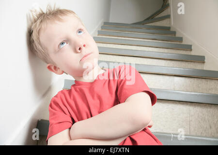 Vernachlässigte einsame Kind an die Wand gelehnt Stockfoto