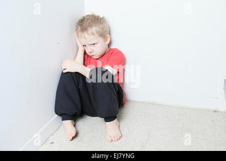 Vernachlässigte einsame Kind an die Wand gelehnt Stockfoto