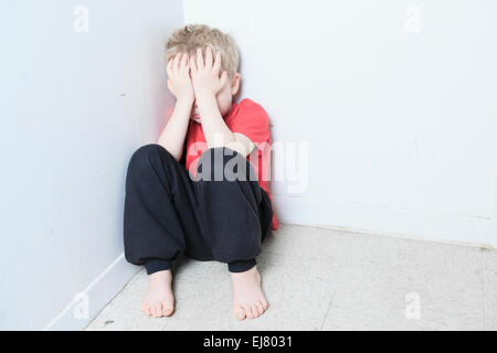 Vernachlässigte einsame Kind an die Wand gelehnt Stockfoto