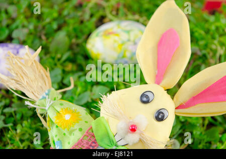 Easter Bunny Puppe und ein Wasser gefärbt Ei auf der Wiese liegend Stockfoto